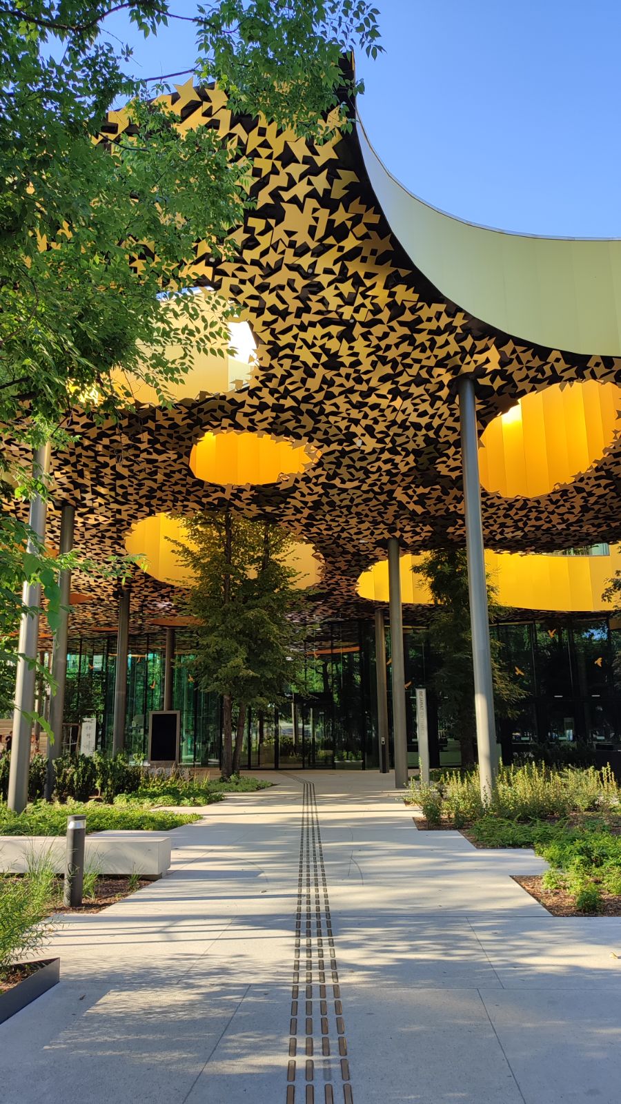 A perforated golden canopy above a path
