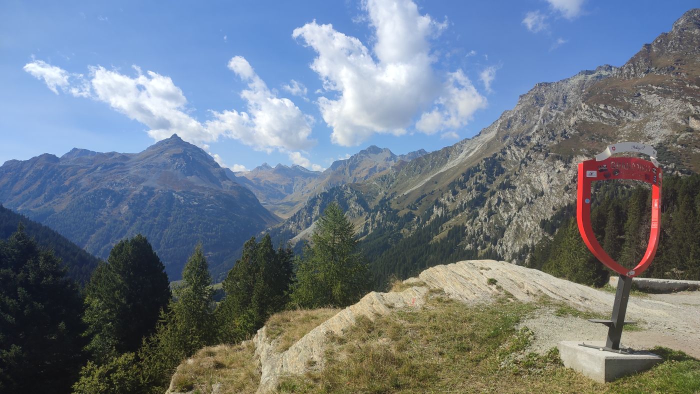 An alpine valley with a red frame at a viewpoint