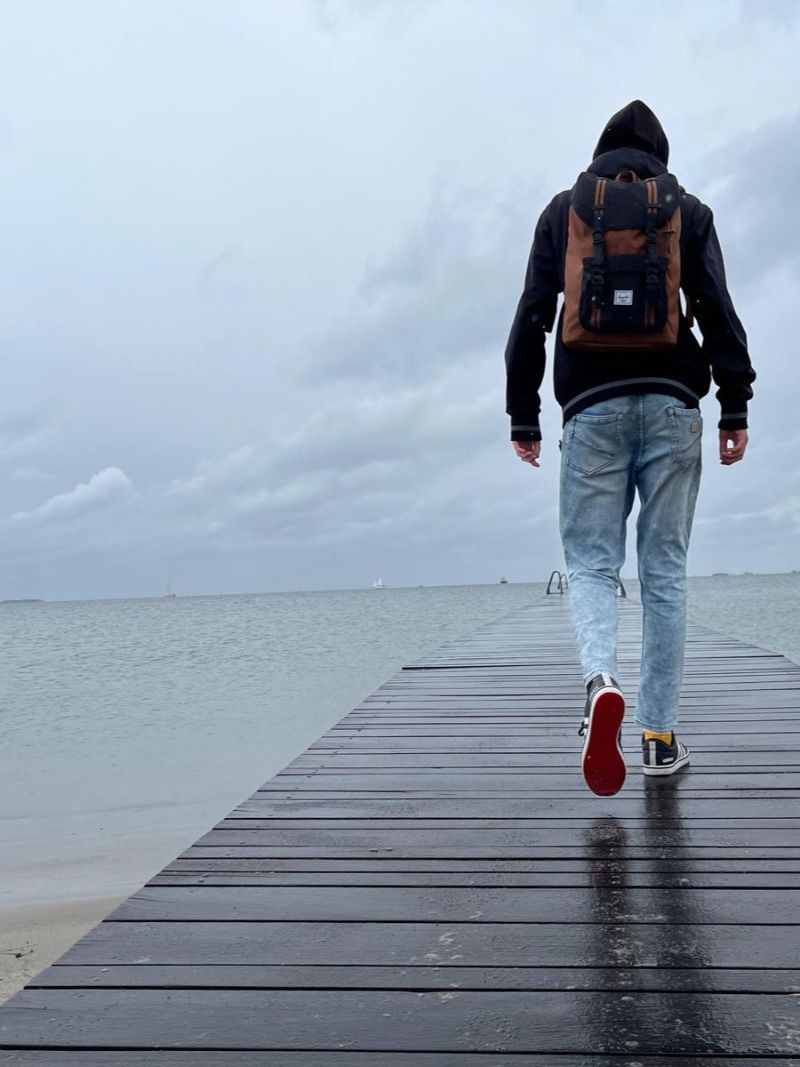 Walking along a wet pier into the sea