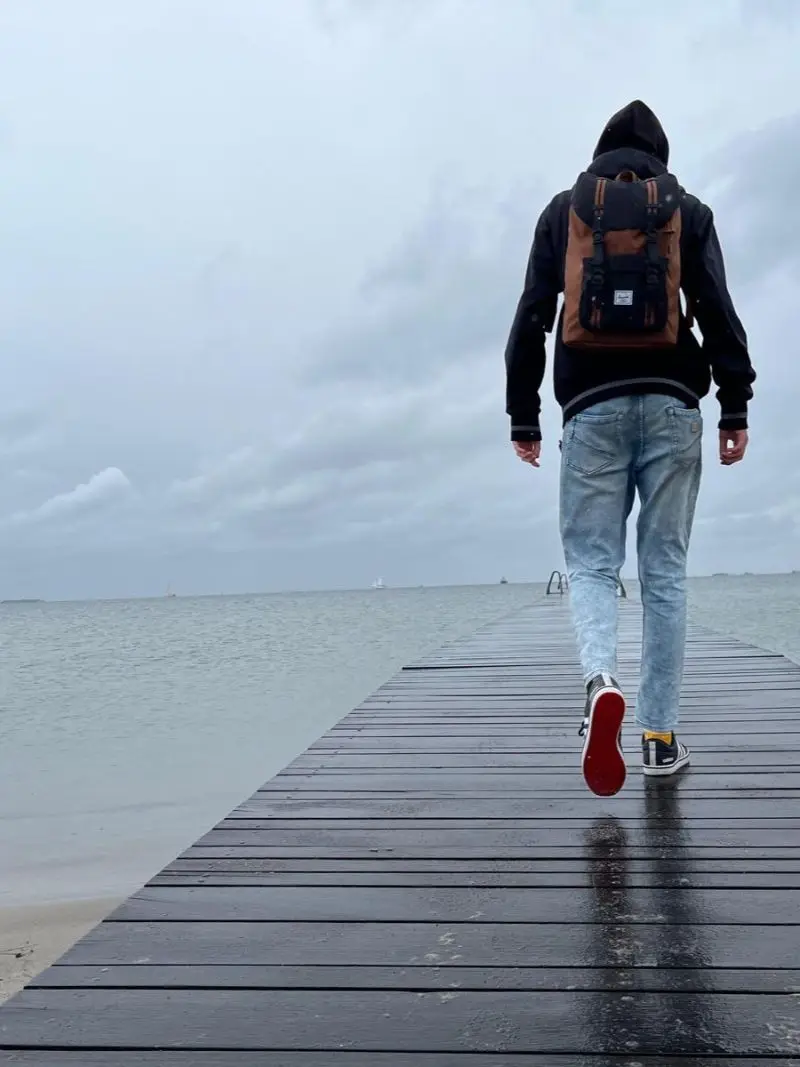 Walking along a wet pier into the sea