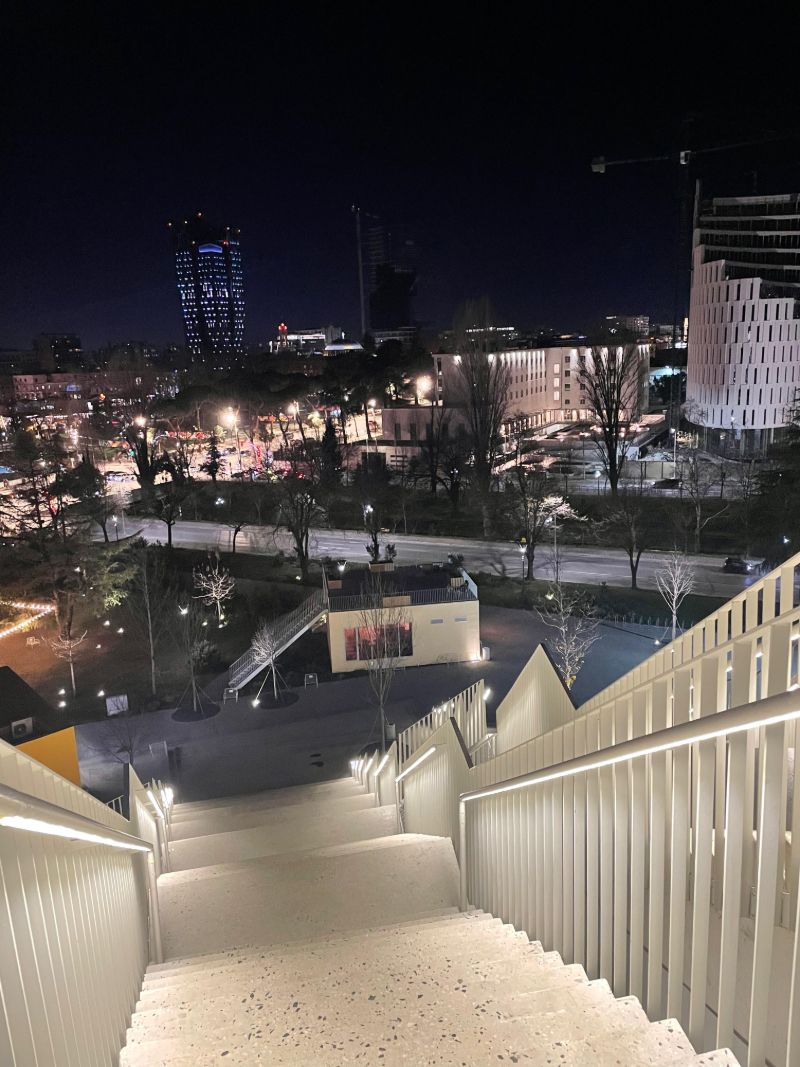 City lights seen from lit stairs at night