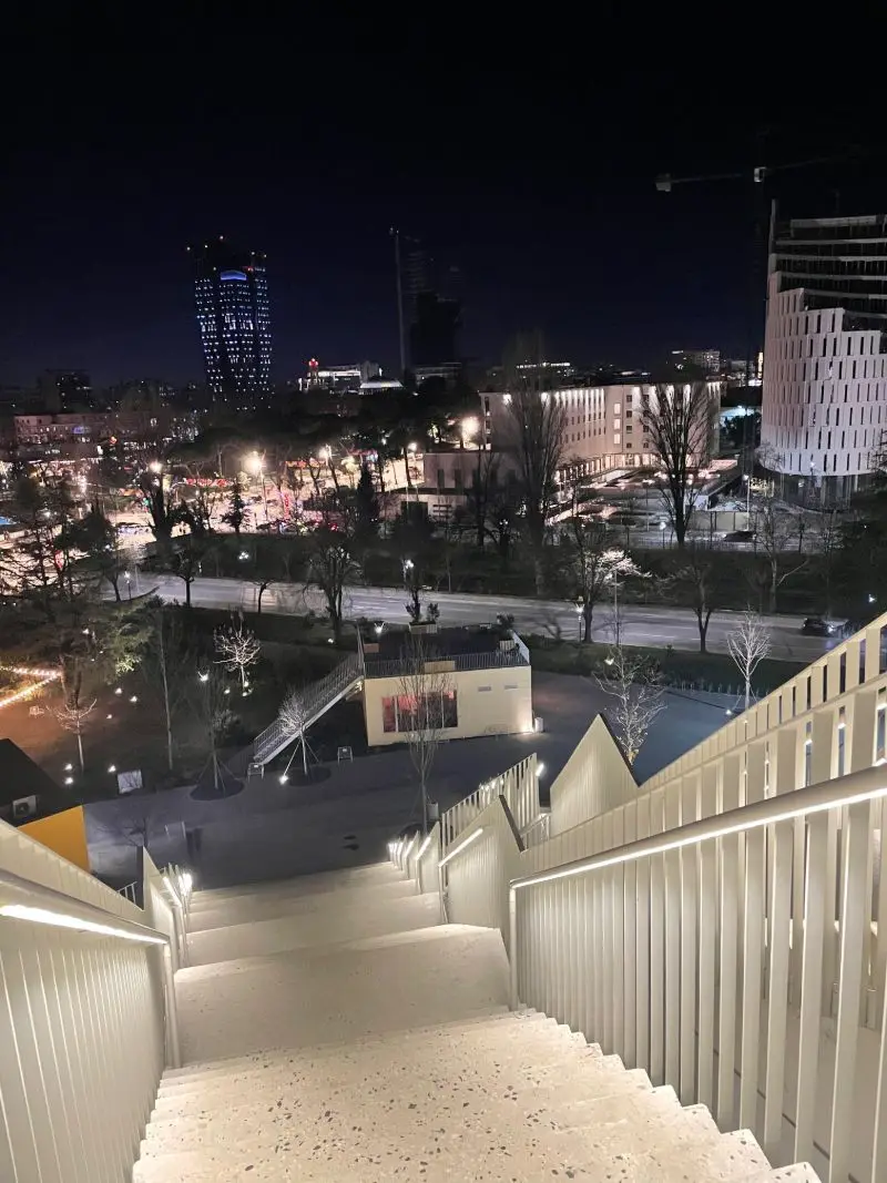 City lights seen from lit stairs at night